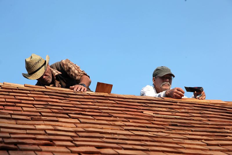 Roofers laying cedar shingles